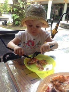 "Look, mum! I'm using very good table manners!" says T, our resident brown-noser, as she tucks into a pizza, of all things.
